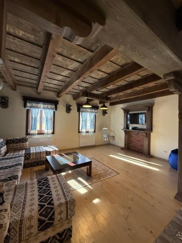 een grote woonkamer met een bank en een tafel bij Căsuțele Craiului in Zărneşti