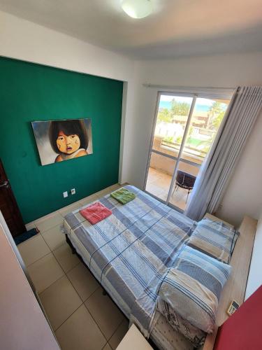a bedroom with a bed with a painting on the wall at O Rei Do Cumbuco - Cumbuco Residence in Caucaia