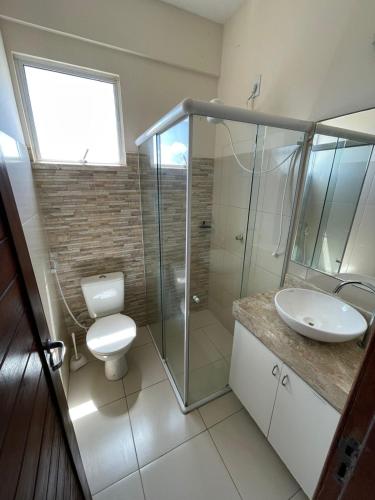 a bathroom with a shower and a toilet and a sink at O Rei Do Cumbuco - Cumbuco Residence in Caucaia