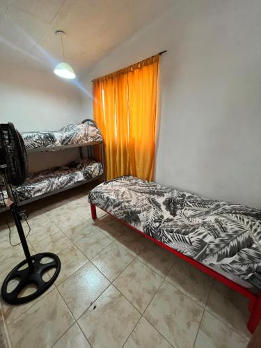 Habitación con 2 literas y cortina de color naranja en Casa de verano Marcos Lopez, en Villa Cura Brochero