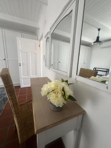 a vase of flowers on a table in a room at Wild Riverside Cottage in Velddrif