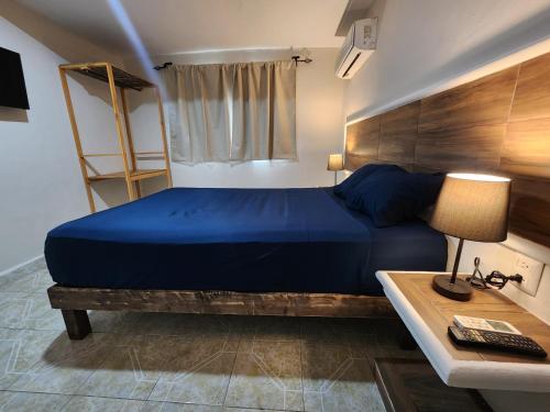 a bedroom with a blue bed and a desk with a lamp at Casa Seloria in Cancún