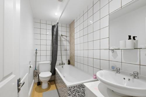 a white bathroom with a sink and a toilet at Comfy 3 bed Home in London in Elmers End