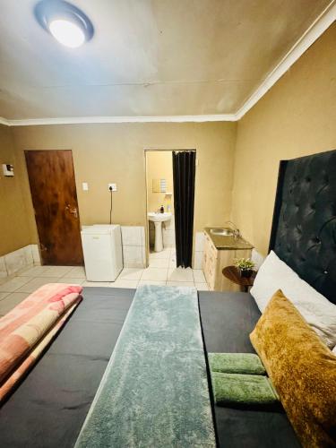 a large room with a bed and a bathroom at Tseleng Guest House in Vosloorus