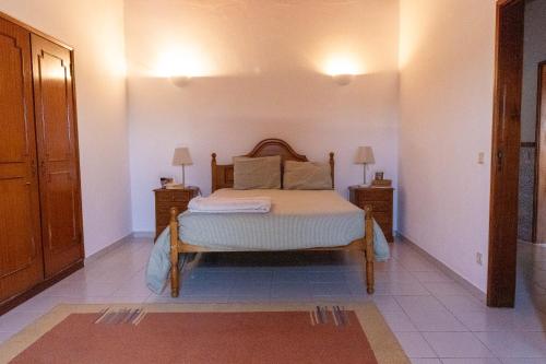 a bedroom with a bed and two night stands at Edu Stay Mondego in São Pedro de Alva