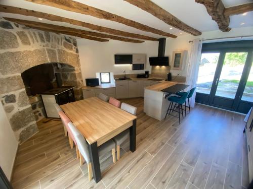 a kitchen and living room with a table and a fireplace at Gîte de Vareilles in Banes