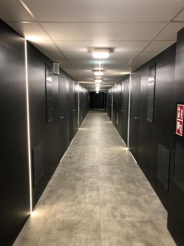a long hallway with black walls and a long aisle at Apartimento Hydral Sole in Wrocław
