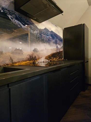 a kitchen with a mountain mural on the wall at Barn&Haus-Stodoły Widokowe in Zubrzyca Dolna