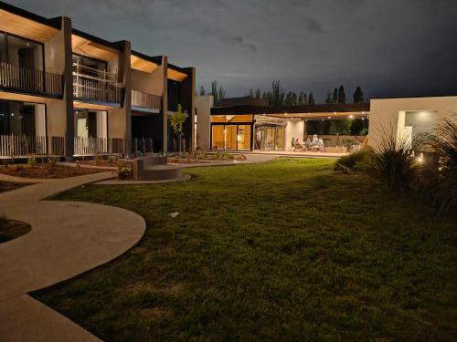 a large building with a lawn in front of it at Vistalba Hotel Aparts & Suites in Ciudad Lujan de Cuyo