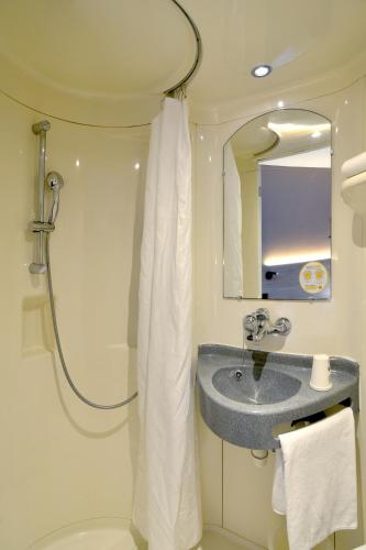 a bathroom with a sink and a shower at Premiere Classe Dunkerque Loon Plage in Loon-Plage