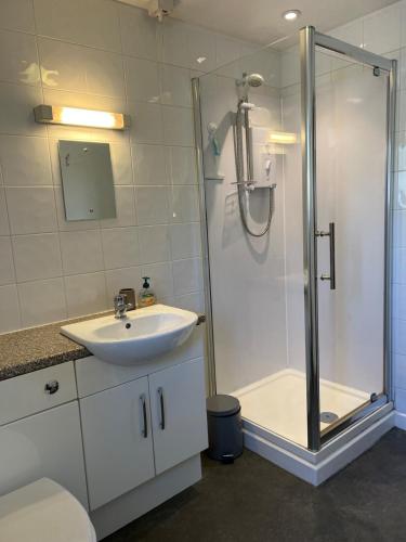 a bathroom with a sink and a shower at Roan Cottage in Royal Wootton Bassett