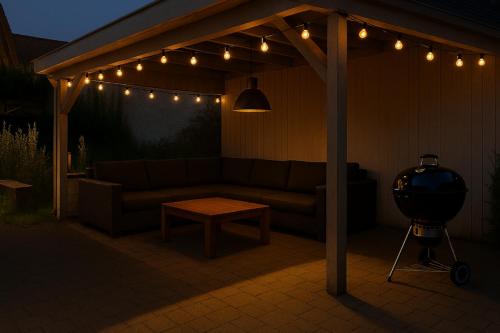 a patio with a couch and a table and lights at Apartment nahe Frankfurt am Main mit Parkplätzen PKW oder VAN in Rödermark