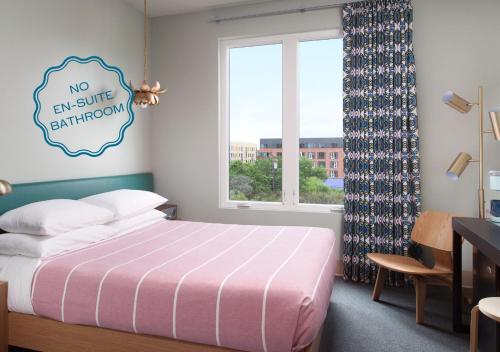 a bedroom with a bed and a window and a desk at The Cabins at East Austin Hotel in Austin