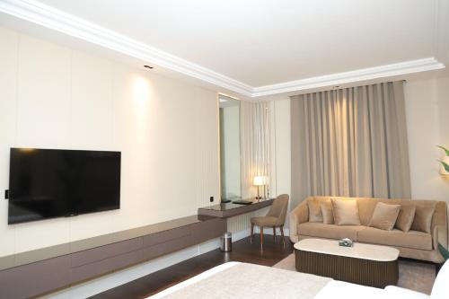a living room with a couch and a flat screen tv at Faletti's Boutique Multan in Dargai