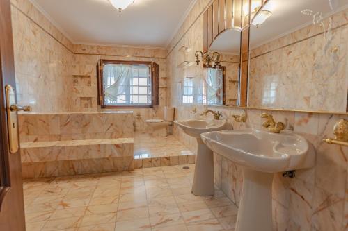a bathroom with two sinks and a tub and a toilet at Casona BRETEMA in Piñeiro