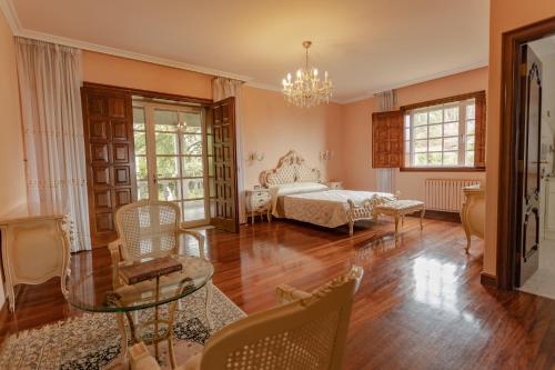 a bedroom with a bed and a table and chairs at Casona BRETEMA in Piñeiro