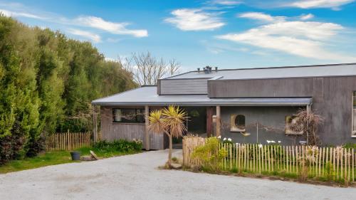 une maison avec une clôture devant dans l'établissement La villa Grand Ouest, à Plounéour-Trez