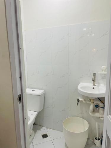 a white bathroom with a toilet and a sink at JC7 Twin Bed City Center Studio JEMS Bldg 3rd Floor IAN UNIT in Oaig Daya