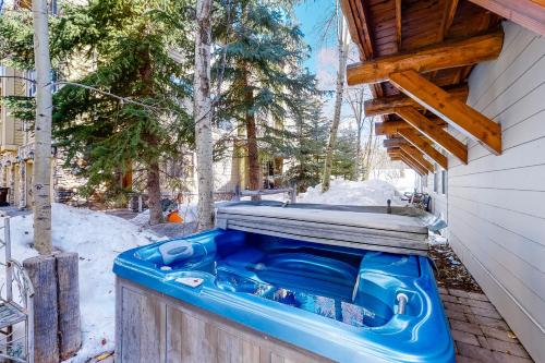 une baignoire bleue posée à l'extérieur d'une maison sous la neige dans l'établissement Sun Bird Getaway at River Run B, à Ketchum