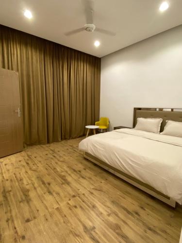 a bedroom with a bed and a wooden floor at شاليه ڤيو - View Chalet in Al Ḩadd