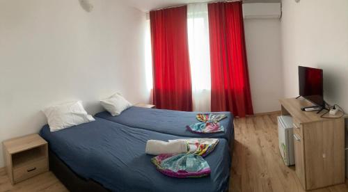 a bedroom with a blue bed and a red curtain at Casa De Zambini in Plovdiv