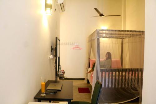 Una habitación con una cama y una mujer en un dormitorio. en Unawatuna Guest, en Unawatuna