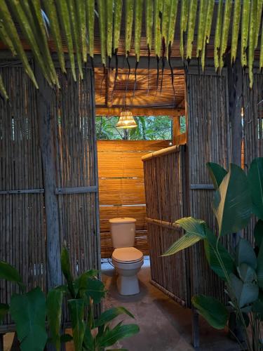 a bathroom with a toilet in a hut at Manoush Beach in Buritaca