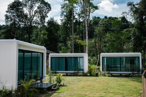 two green and white modular homes in a yard at Koh Kood AYA Homestay in Ko Kood