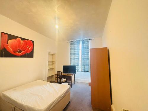 a bedroom with a bed and a desk and a window at Vintage Thistle House in Glasgow