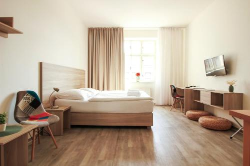 Un dormitorio con una cama y un escritorio y una ventana. en Hotel Palác Elektra, en Ostrava
