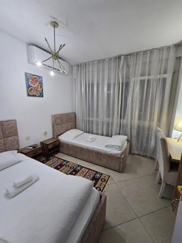 a hotel room with two beds and a window at Isabel Rooms in Tirana