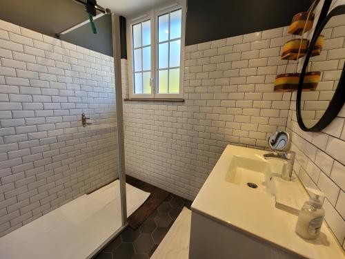 un baño con lavabo y ducha en Au Grand Mur, en Neuvic