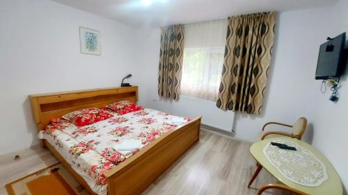 Vadu MoţilorにあるCabana La Cucuのベッドとテーブルと窓のある寝室