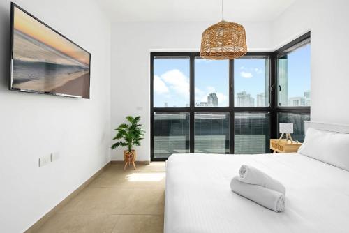 a bedroom with a white bed and large windows at O&O Group- Modern Luxury APT-Mesmerizing Sea Views in Bat Yam