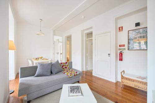 a living room with a couch and a table at Cozy Apartment with Castel view in Lisbon