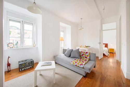 a living room with a couch and a table at Cozy Apartment with Castel view in Lisbon