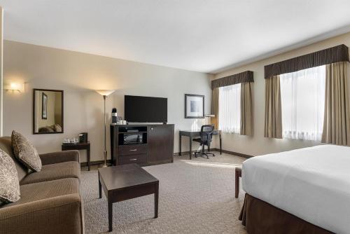 a hotel room with a bed and a living room at Best Western Plus Baker Street Inn in Nelson