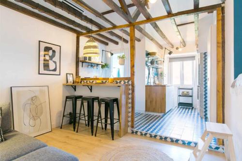 a living room with a bar with stools at Design Studio em Alcântara- LX Factory- 1 MAIO in Lisbon