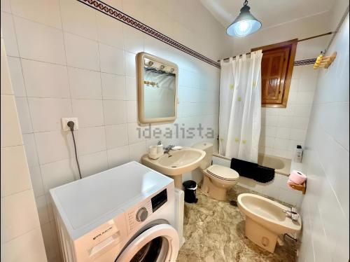 a white bathroom with a washing machine in it at Apartamento Rey Melchor in Trevélez