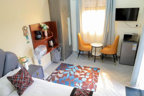 a living room with a bed and chairs in a room at Luxury Gem in Nsambya 1km from American Embassy in Kampala