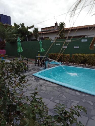 a swimming pool with a water fountain at Pousada e Hostel F C in Natal