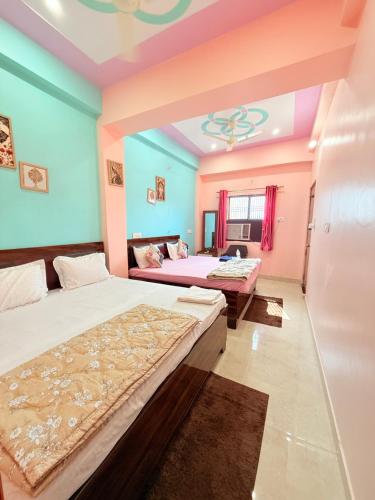 two beds in a room with blue and pink walls at ATULYAM STAYs PREMIUM in Ayodhya