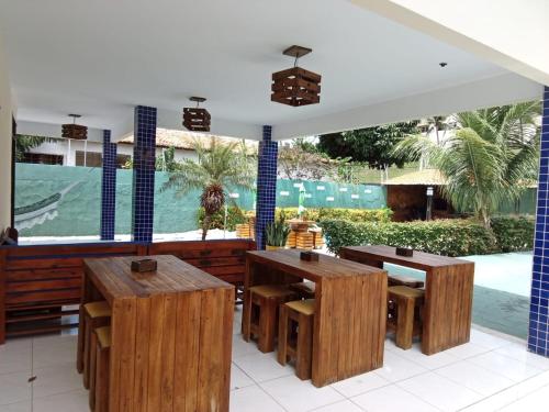 a patio with tables and benches and a swimming pool at Pousada e Hostel F C in Natal