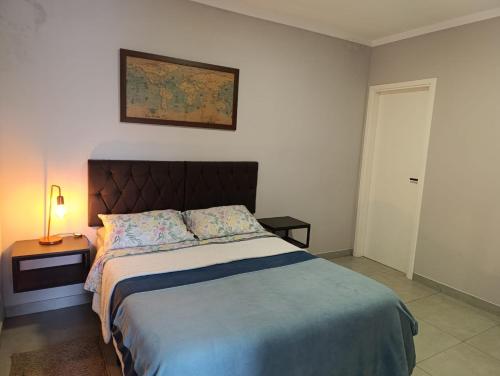 a bedroom with a bed and a picture on the wall at Apê Bella Vista Campos in Campos do Jordão