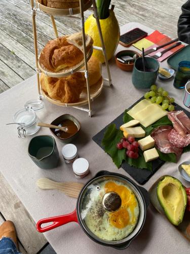 una mesa cubierta con queso y pan y un plato de comida en Chez Eloi, en Tacfesse