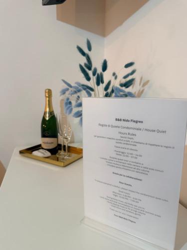 a table with a menu and a bottle of champagne at Nido Flegreo in Pozzuoli