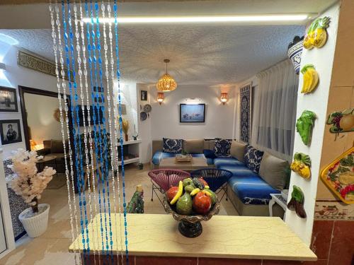 a living room with a couch and a bowl of fruit on a table at Apartment in Martil in Martil