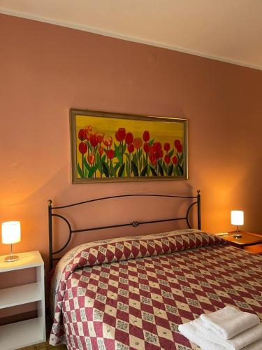 a bedroom with a bed with a painting on the wall at Casa vacanze di Angelo in Isnello