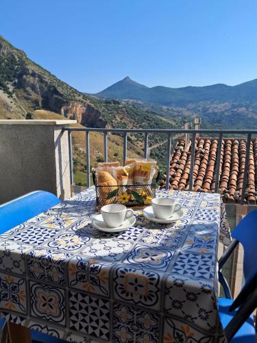 a table with two cups and saucers on a balcony at Casa vacanze di Angelo in Isnello