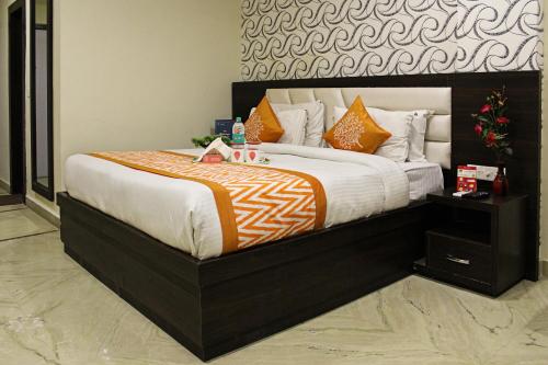 Un dormitorio con una cama grande con un edredón naranja y blanco. en Hotel O Tajway Inn, en Agra